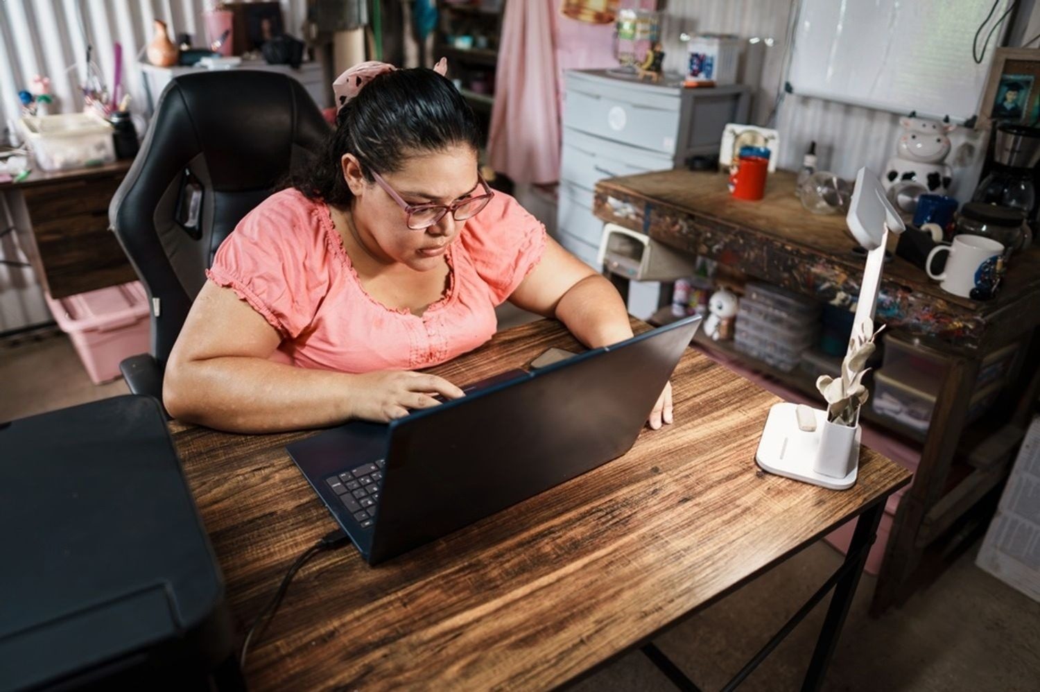 Una señora trabaja concentrada con su computadora portátil en casa